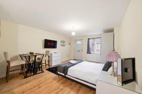 una camera con un letto e un tavolo di LT Properties comfy Studio Apartment a Luton