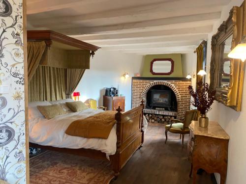 a bedroom with a large bed and a fireplace at Moon River Bellac Chambre d'hotes in Bellac