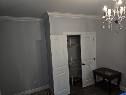 a room with a chandelier and a door to a closet at Oscar INN & 2bd Family Suite or Private Room in Abbotsford