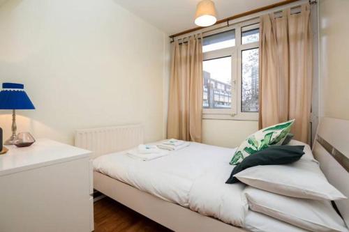 a bedroom with a white bed with a window at 3 Bedroom Flat in Central London in London