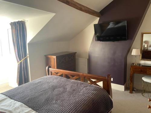 a bedroom with a bed and a tv on the wall at County Loft Penthouse Apartment in Whitby