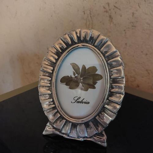 un piatto d'argento con un fiore in cima a un tavolo di Istanti - Salvia a Costigliole Saluzzo