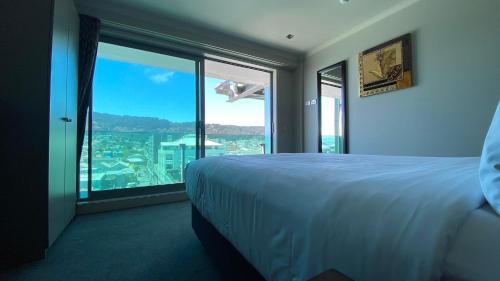 a hotel room with a bed and a large window at Tory Hotel in Wellington