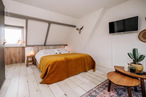 sypialnia z łóżkiem i telewizorem z płaskim ekranem w obiekcie Zandvoortferienwohnungen w Zandvoort