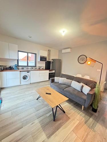 a living room with a couch and a table at Bella Vista, parking gratuit, 5 min Auxerre in Monéteau