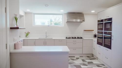 a white kitchen with a sink and a window at Sligo Sea Barn in Sligo