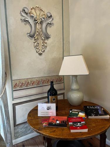 a table with a bottle of wine and a lamp at Maestra Exclusive Chianti House, Tuscany in Poggibonsi