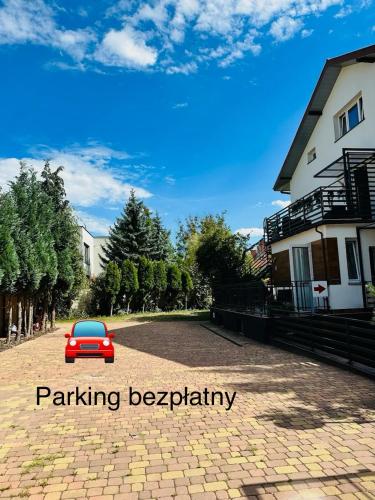 a small red car parked on a brick road at Apartamenty Pokoje Willa Bielany in Warsaw
