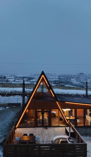 a large wooden house with a deck in the snow at Cabana Stil A in Mărişel