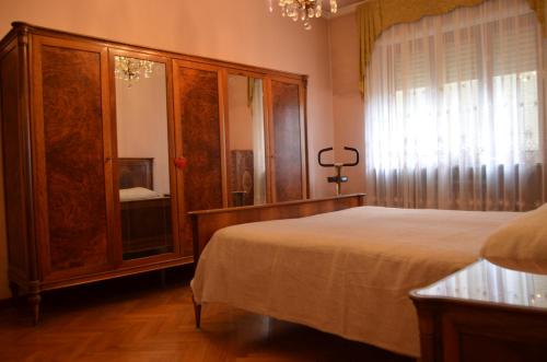 1 dormitorio con 1 cama y un gran armario de madera en Eleganza vicino al centro di Torino en Turín