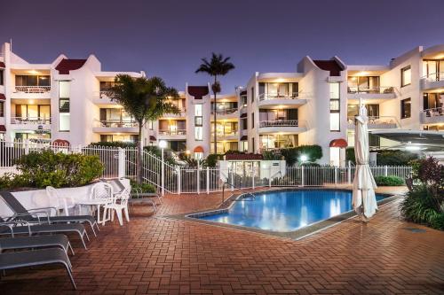 a swimming pool in front of a apartment building at Alexandria Apartments in Alexandra Headland