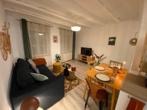 ein Wohnzimmer mit einem Sofa und einem Tisch in der Unterkunft A22 - Les Cosy De Nancy - Le bohème chic 4* in Nancy