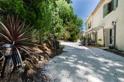 a dirt road next to a building with a plant at VILLA ISABELLE -2 Appartements - 2 Jacuzzi privatifs in Saint-Étienne-de-Fontbellon