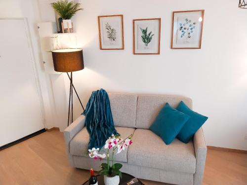 a living room with a gray couch with blue pillows at Escapade au cœur de Luce chartres in Luce