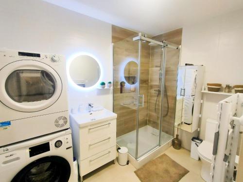 a bathroom with a shower and a washing machine at Escapade au cœur de Luce chartres in Luce