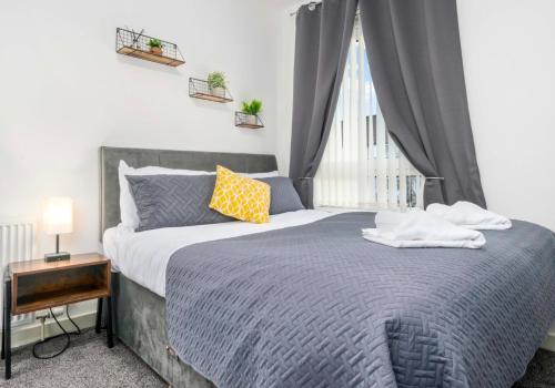 1 dormitorio con cama y ventana en Lady Wilson Apartment by Klass Living Airdrie en Airdrie