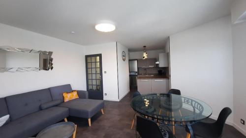 un salon avec un canapé bleu et une table en verre dans l'établissement 7 Quai Des Rêves 3 étoiles !, à Sète