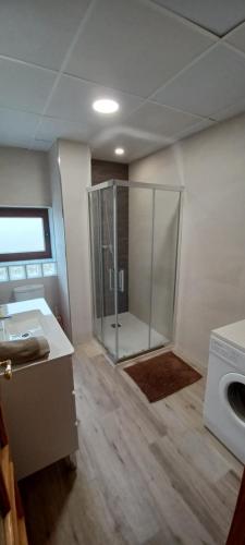 a bathroom with a shower and a washing machine at Villa Cuesta Colorada in Huétor Santillán