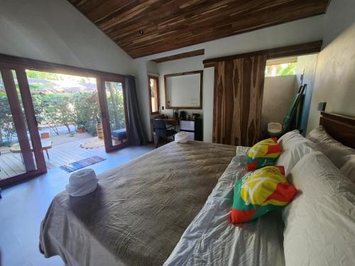 sypialnia z dużym łóżkiem i dużym oknem w obiekcie Villas Pura Vibra w mieście Potrero