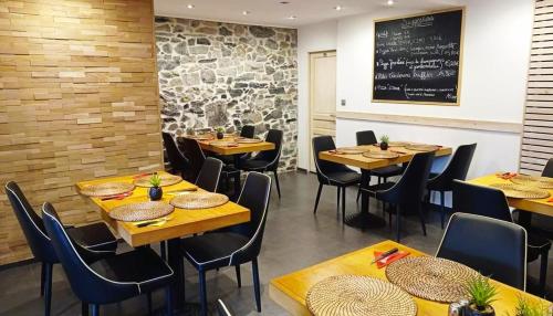 a restaurant with wooden tables and chairs and a chalkboard at Le Route 80 in Namur