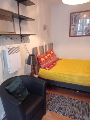 Cette chambre comprend un lit et une chaise. dans l'établissement 2 pièces Paris 9 ème, à Paris