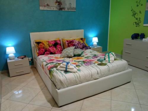 um quarto com uma cama branca com flores em Light Blue Room em Scordia