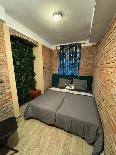 Stay in Poznan Tropical في بوزنان: غرفة نوم بسرير كبير في جدار من الطوب