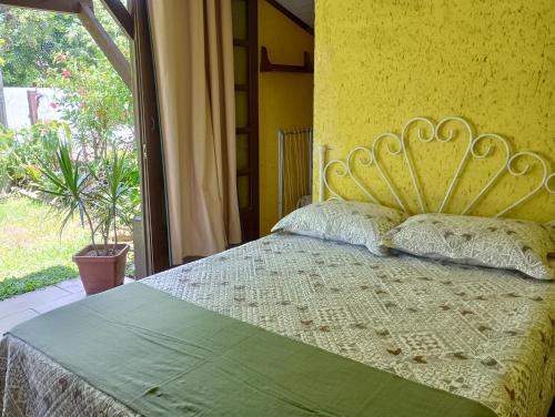 a bedroom with a bed with a large window at Hibisco Rosa Aluguéis in Araçatuba