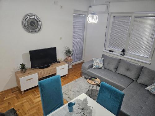 a living room with a couch and a tv at Apartman Odmor012 in Požarevac