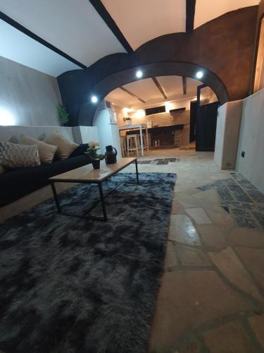 ein Wohnzimmer mit einem Sofa und einem Tisch in der Unterkunft Appartement de charme in Longvic