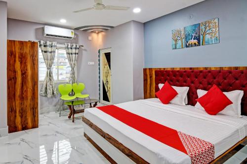 OYO Tara Maa Guest House في كولْكاتا: غرفة نوم بسرير كبير مع اللوح الأمامي الأحمر