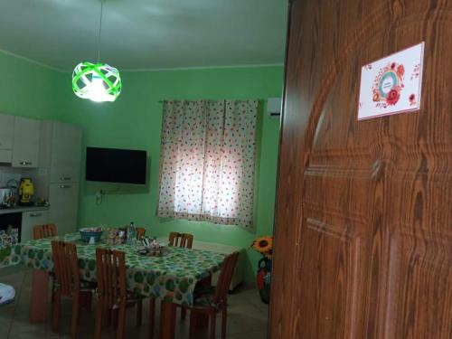 Un comedor con una mesa y una cocina. en Rainbow Apartment, en Scordia