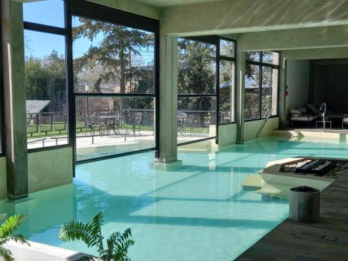 a large swimming pool with blue water and windows at Los Robles Apart Hotel in Sierra de la Ventana