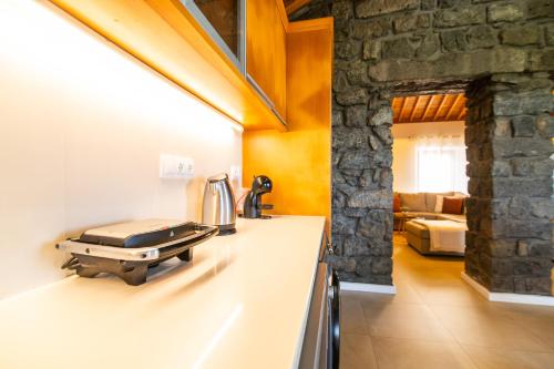 a kitchen with a counter with a sink and a room at Casa da Belavista with Jacuzzi in Nordeste