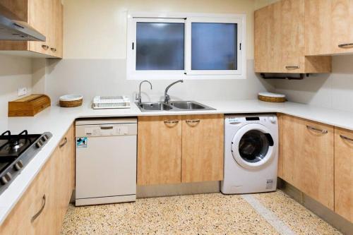 a kitchen with a washing machine and a sink at Niu d'Oreneta in Canet de Mar