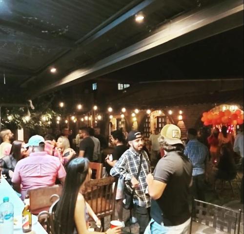 a group of people standing in a bar at Old Bells Hostel in Santa Ana