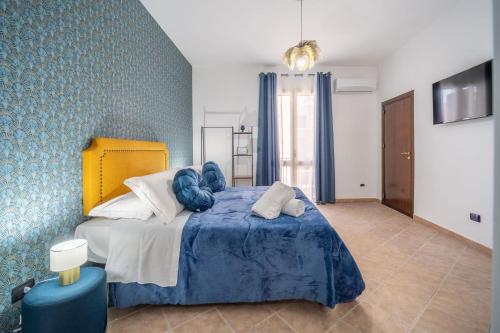 a bedroom with a large bed with a blue blanket at la porta di Alba in Palermo