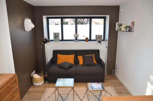 a living room with a couch and a window at Le Burlat - Studio - Lyon - Tassin in Tassin-la-Demi-Lune