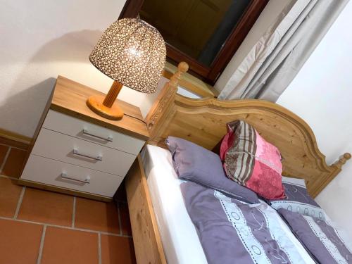 a bed with a wooden headboard and a lamp at Ferienhaus Almenland in Arzberg