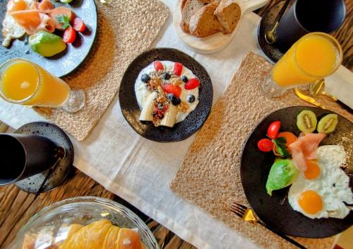 uma mesa com pratos de comida e copos de sumo de laranja em Casa by Anita Guesthouse em Esposende