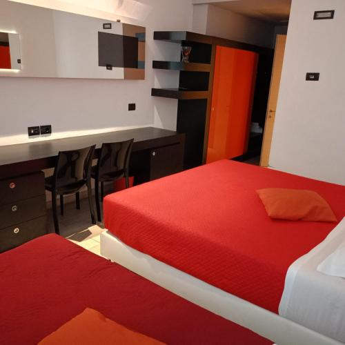 a hotel room with two beds and a desk and a table at Blue Shades Hotel in Pisa