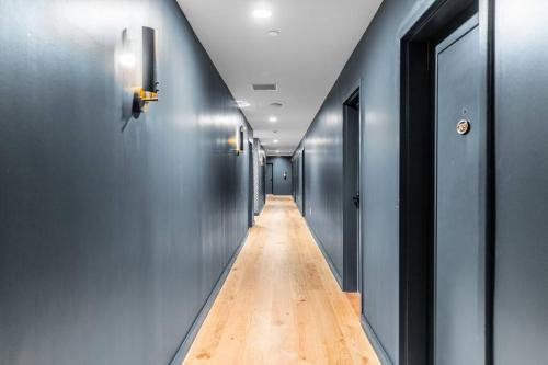a long hallway with blue walls and a wooden floor at The Phenix Historic DWTN Hotel, King Bed, Room # 306 in Bangor