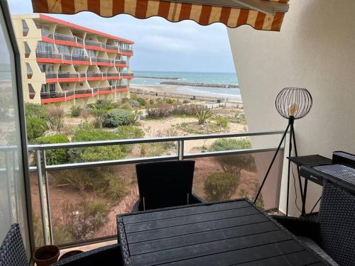 balcón con mesa y vistas a la playa en Face à la mer, au Zénith en Palavas-les-Flots