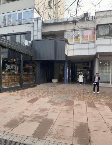 a woman is standing in front of a building at MINA modern & cozy apartment main city square GTC Skopje in Skopje