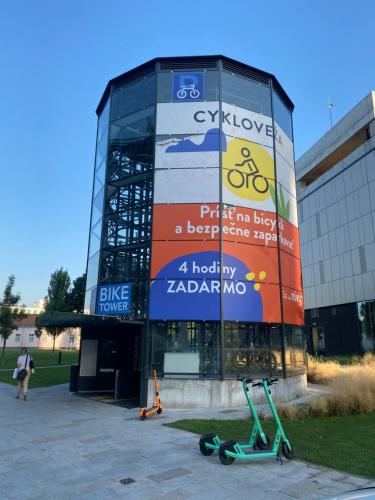 a large glass building with a sign on it at James Dean apartment - next to Nivy Bus station & Mall (Free parking on the weekend) in Bratislava
