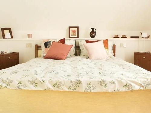 a bed with a white comforter and pillows on it at Villa Anna in San Venanzo