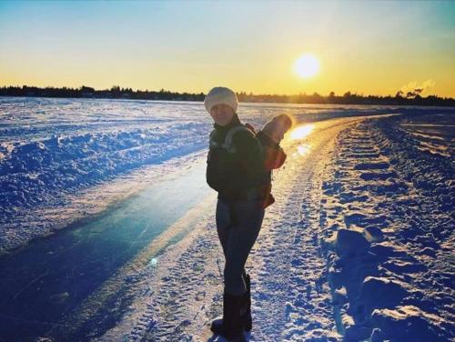 a person walking down a snow covered road with a snowboard at Le gîte du Lac à la Tortue in Herouxville