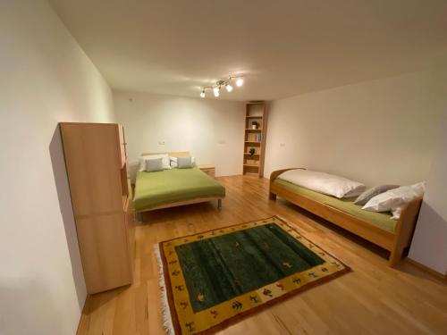 Habitación pequeña con 2 camas y alfombra. en Ferienwohnung Bindl en Ulrichsberg