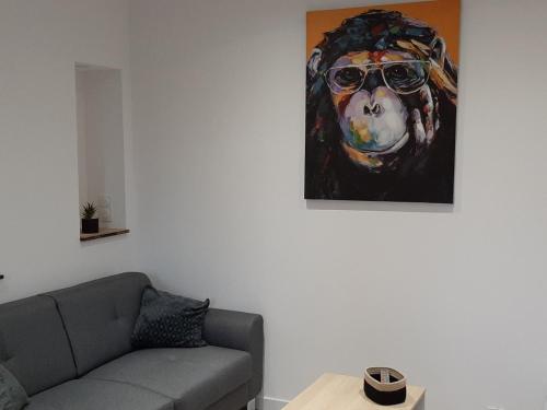 ein Wohnzimmer mit einem Gemälde eines Hundes mit Sonnenbrille in der Unterkunft Logement tout confort Albi in Albi