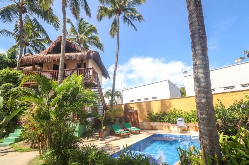 a resort with a swimming pool and palm trees at Pousada Aconchego da Pipa in Pipa